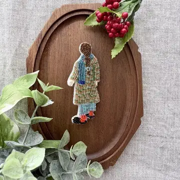 체크 무늬 코트의 여아 브로치