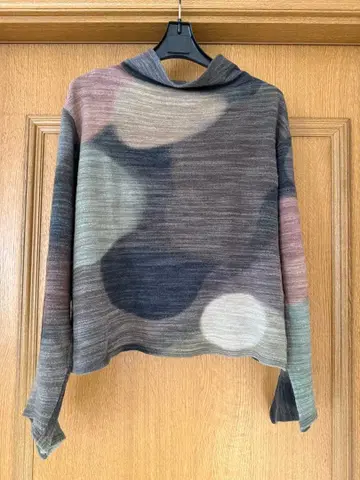 요건 레일 소매가 특징인 다색 추상 무늬 하이넥 니트