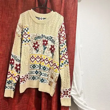 꽃무늬와 기하학 패턴의 크림색 니트 스웨터