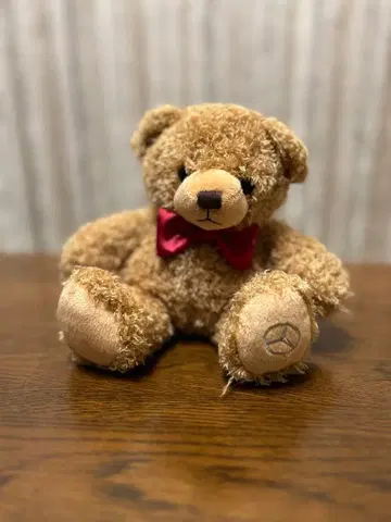 메르세데스 로고가 있는 브라운 봉제 인형