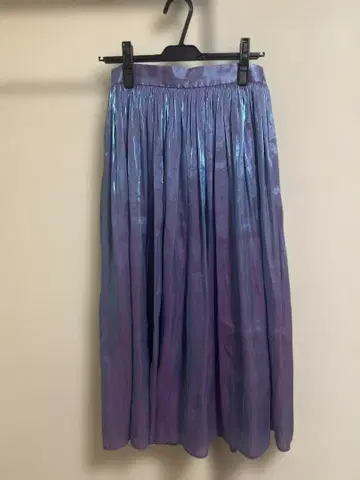광택 있는 보라색과 파란색의 플리츠 스커트