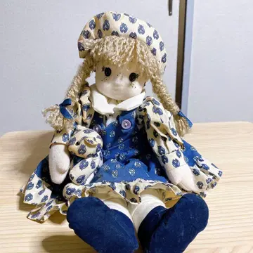 파란색과 흰색 무늬의 여아와 테디베어 인형