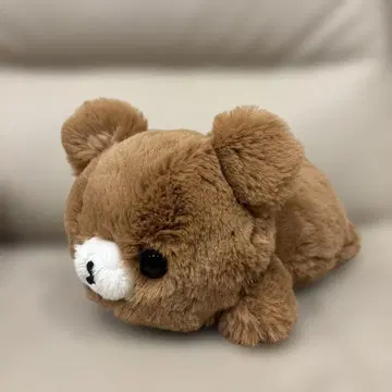 갈색 곰이 푹신하게 엎드린 봉제 인형