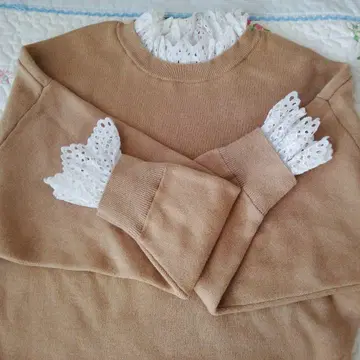 귀여운 엔폴드. 레이스 달린 베이지 니트 스웨터.