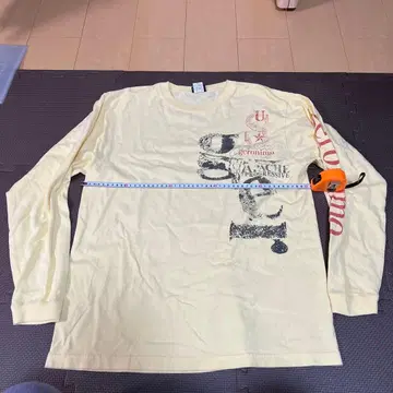 크림색 긴팔 티셔츠 그래픽 프린트