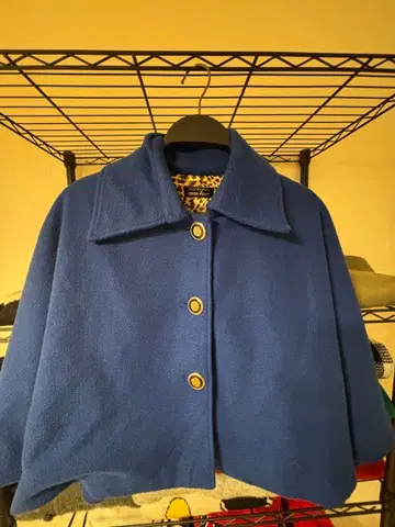 파랑색 버튼이 달린 케이프 코트