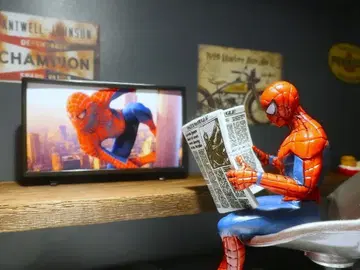 TV를 보면서 자신이 실린 신문을 읽는 스파이더맨 피규어