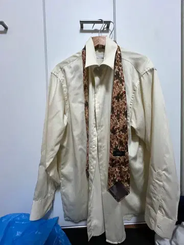 크림색 긴팔 셔츠와 꽃무늬 넥타이