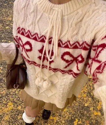 리본 무늬의 크림색 니트 스웨터