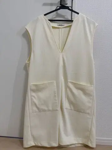 크림색 V넥 슬리브리스 상의