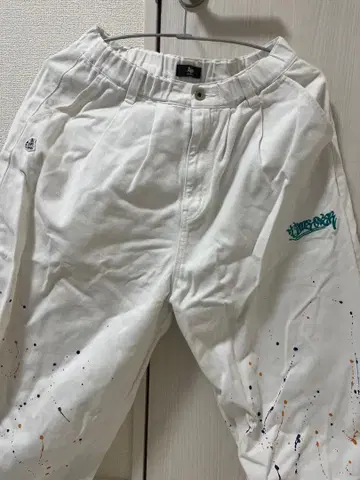A'gem (에이젬)의 페인트 가공이 더해진 화이트 남성 바지입니다