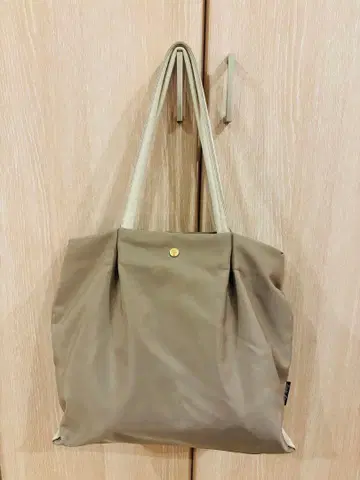 베이지 토트백 복수 포켓 부착