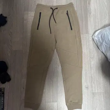 베이지색 조거 팬츠 앞면 지퍼 포켓 포함
