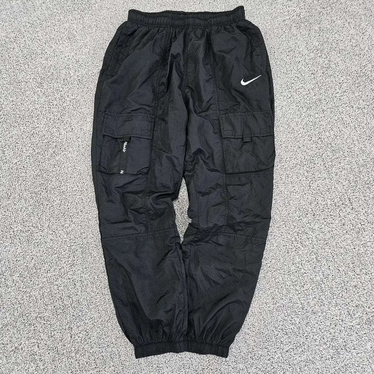 nike all over logo print joggers in camel