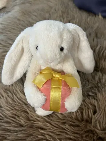 토끼 봉제 인형이 선물을 안고 있는 디자인
