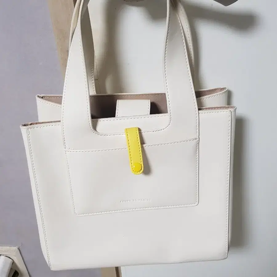 폴스부티크의 매력적인 화이트 토트백이에요가로24세로 22깔끔한 디자인에 옐로우 컬러 포인트가 돋보여요내부 수납 공간도 넉넉해서 실용적이랍니다