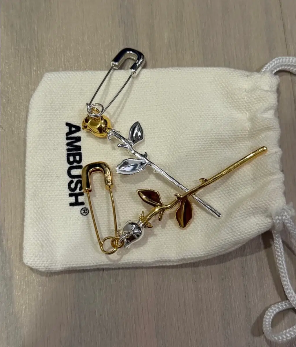 엠부쉬(AMBUSH)의 실버 및 골드 장미 참 싱글 귀걸이