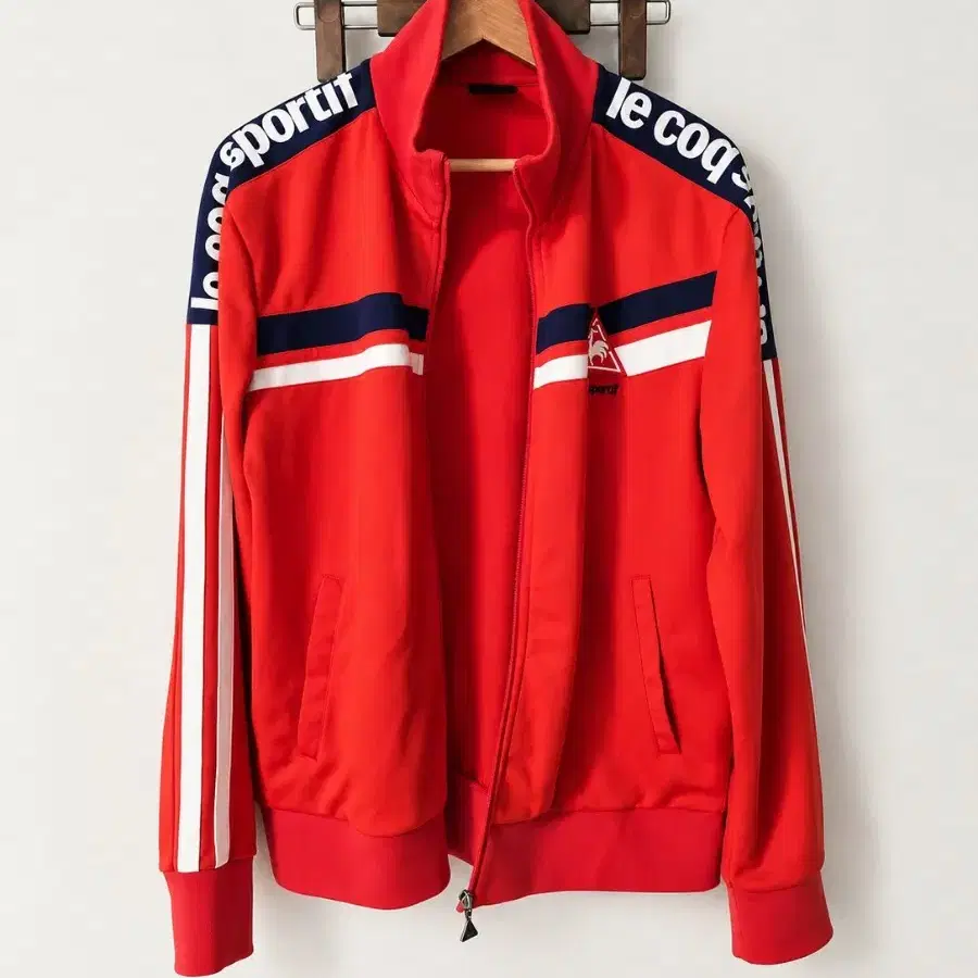 르꼬끄 스포르티브(Le Coq Sportif)의 레드 컬러 트랙탑(집업 져지) 자켓입니다.